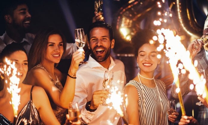Cropped shot of young friends holding sparklers at a party