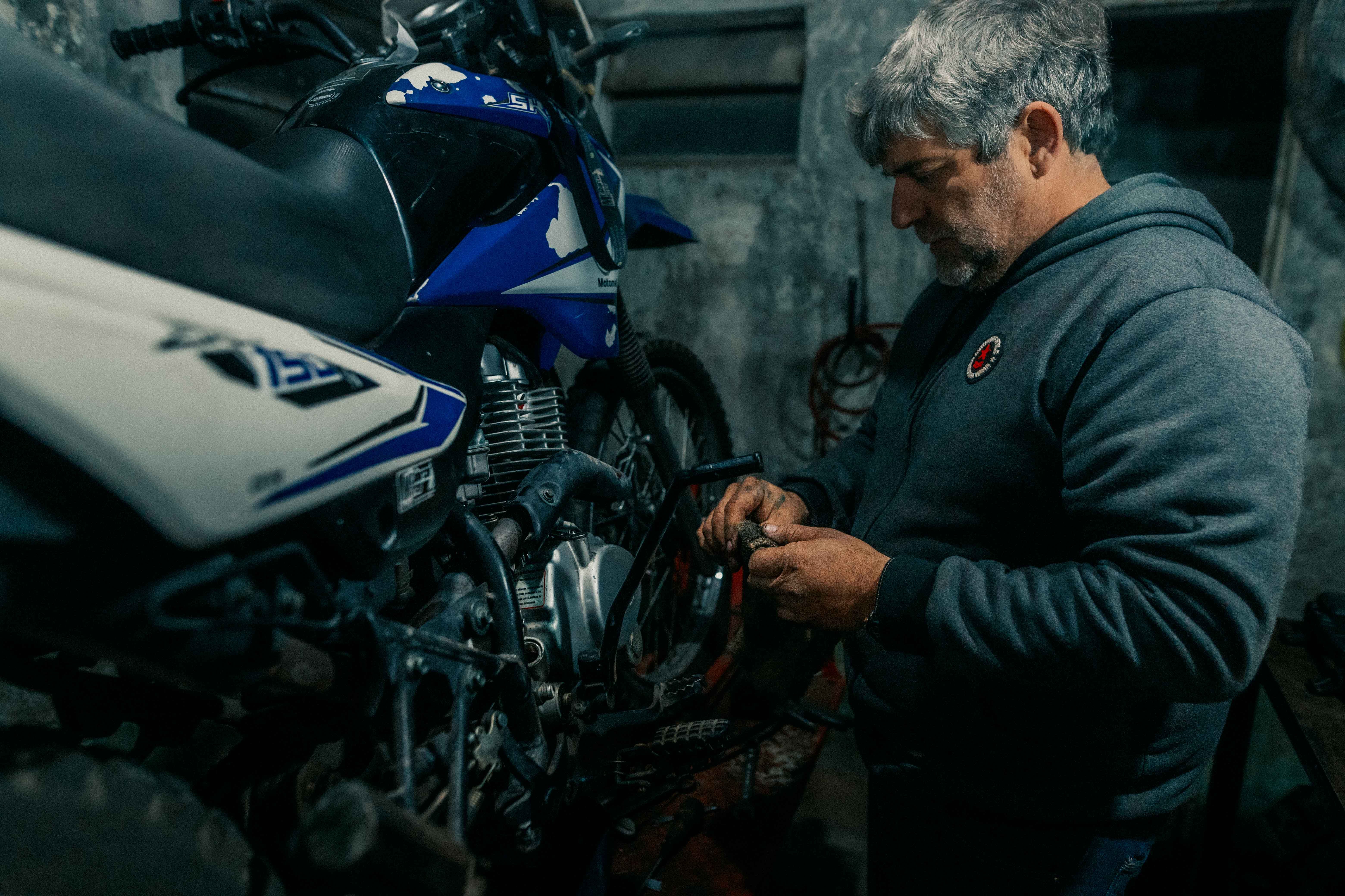 Mechanic repairing a motorcycle in a garage workshop
