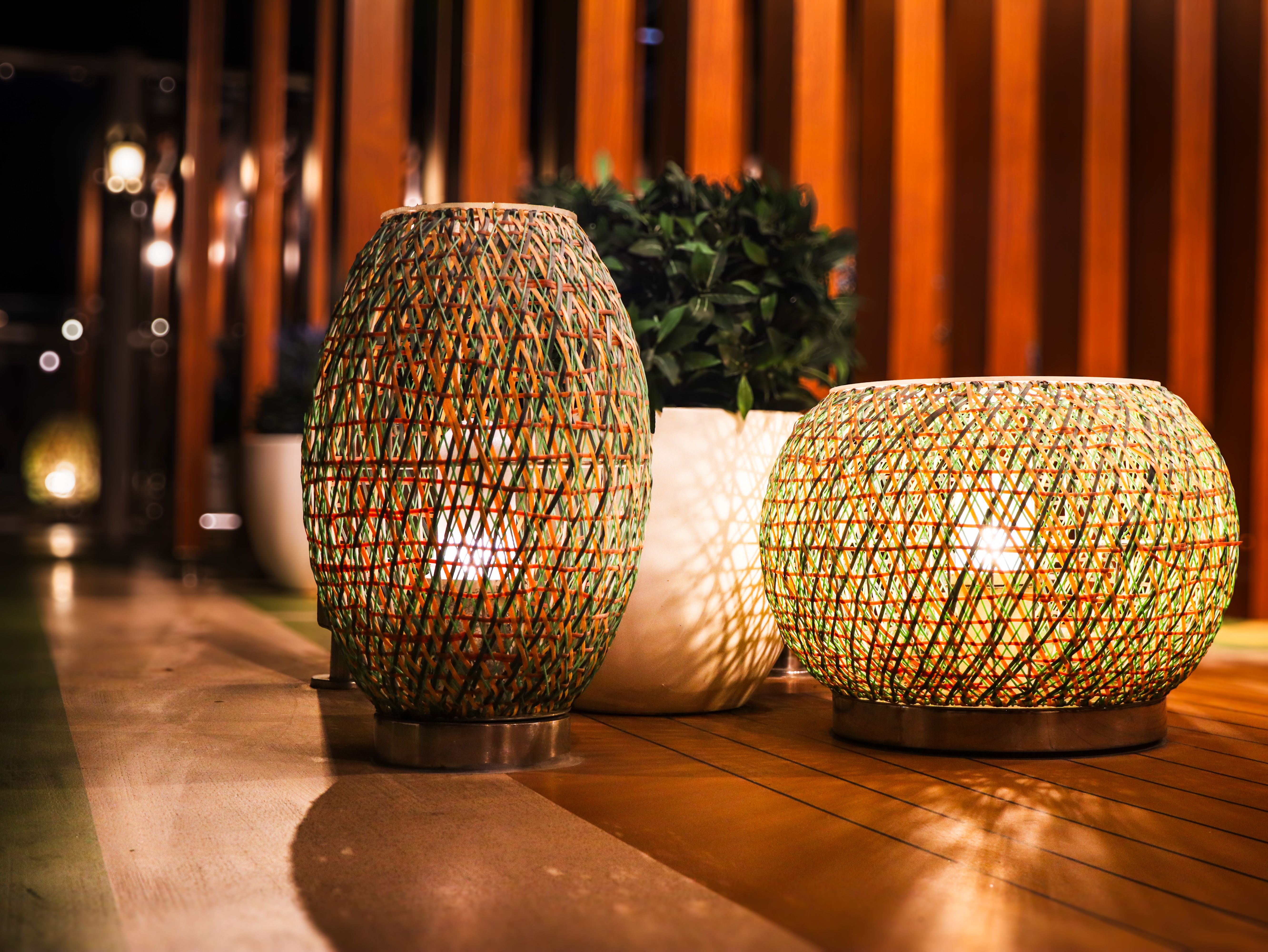 Warm woven lanterns illuminating a wooden patio at night
